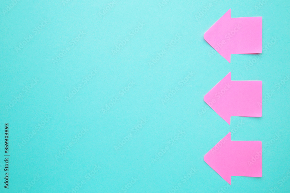 Pink paper sticky notes in shape of arrow on blue background - obrazy, fototapety, plakaty 