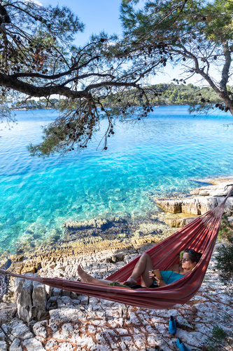 Obraz na płótnie woman with smartphone in hammock on island mljet, croatia w salonie