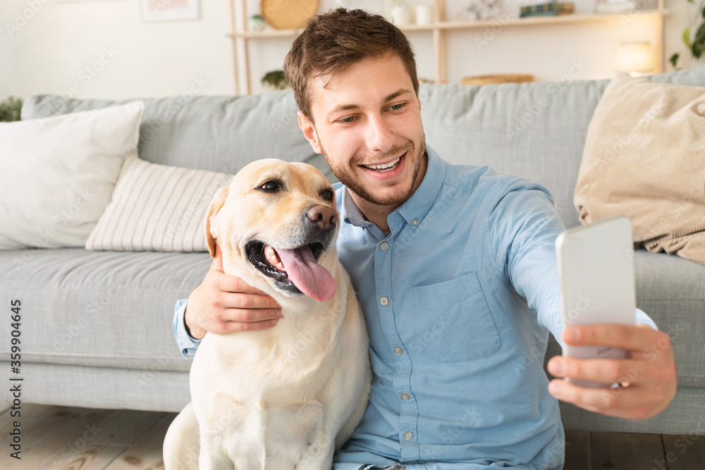 Young man with his dog taking selfportrait at home Young man with his dog taking selfportrait at home