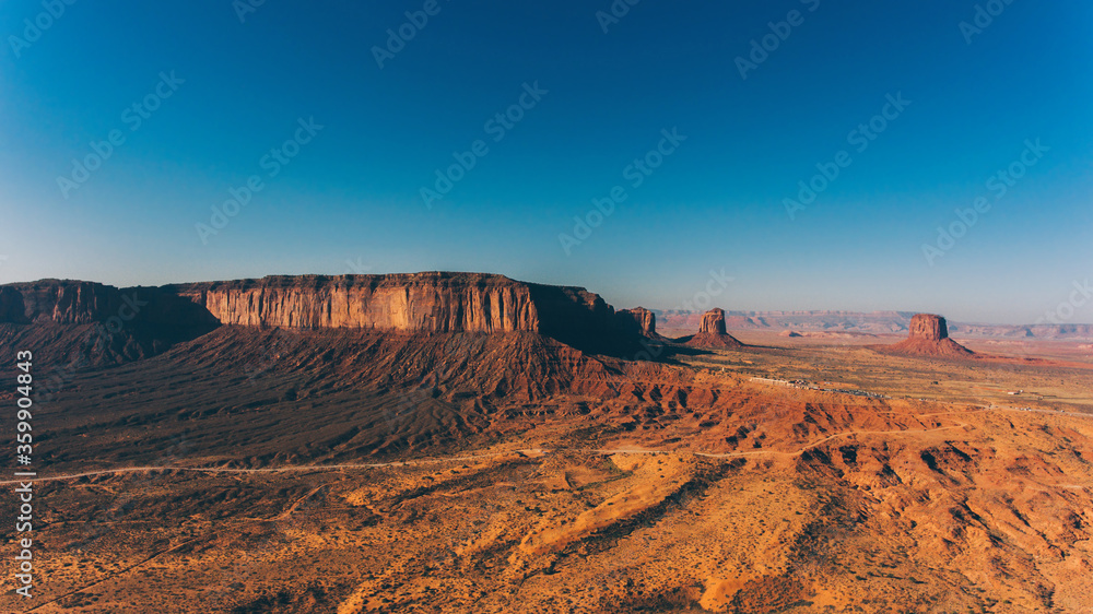 Bird's eye view of beautiful landscapes of southwest USA with blue sky on horizon.Aerial view of endless Monument Valley desert of Utah state