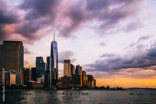 Panoramic view of Manhattan Island with buildings and Hudson river. Scenery skyline view of contemporary glass skyscrapers of downtown financial district in New York. Dramatic sunset sky over city
