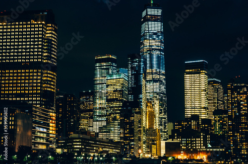 Scenery view of Lower Manhattan skyline at night time with city lights in windows. Beautiful cityscape view of New York downtown. Contemporary metropolis city in need of a huge amount of electricity