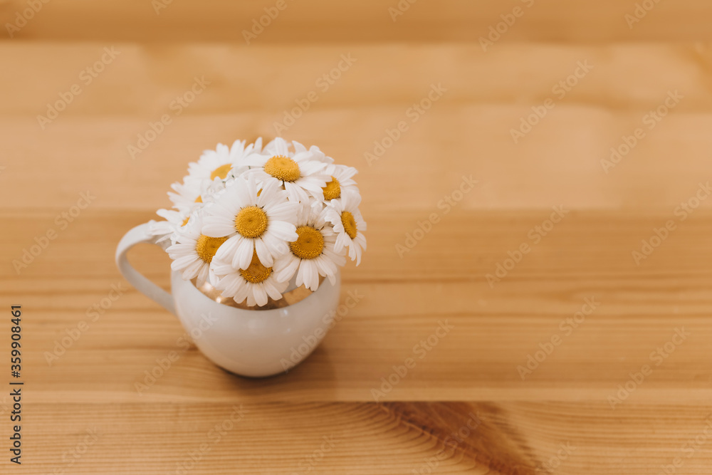 Vase with camomiles on a wooden background. Vase with camomiles on a wooden background.