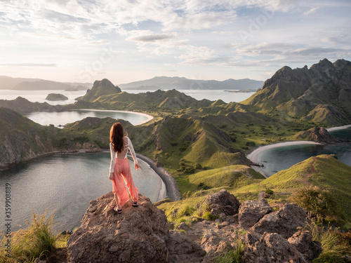 Rear view of a woman standing on hill top looking away.many view from Padar island, Indonesia.