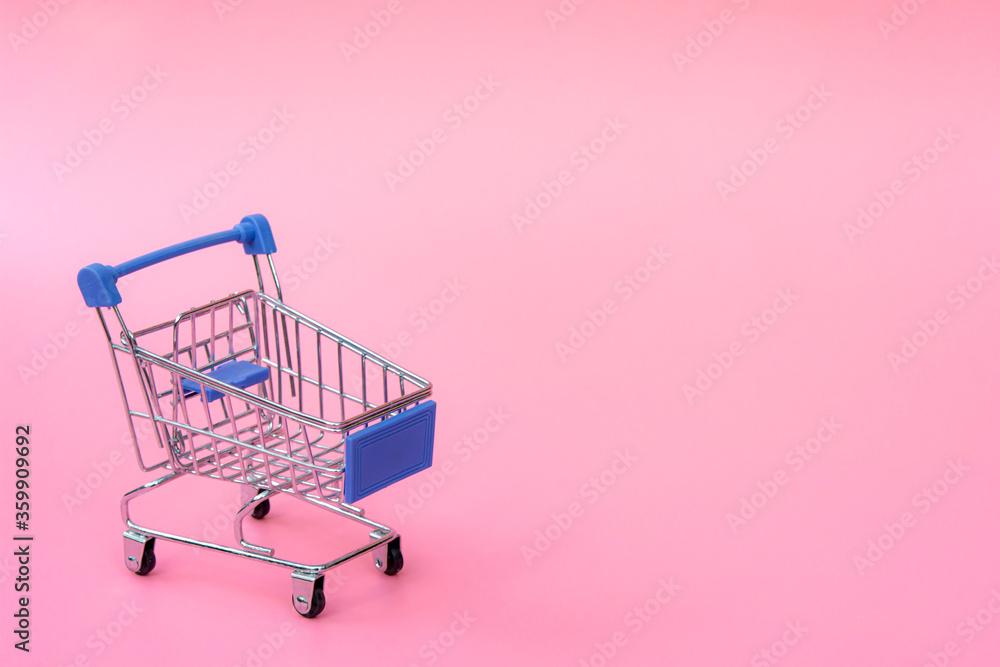 Shopping concept : Blue shopping cart on pink background. online shopping consumers can shop from home and delivery service. with copy space.