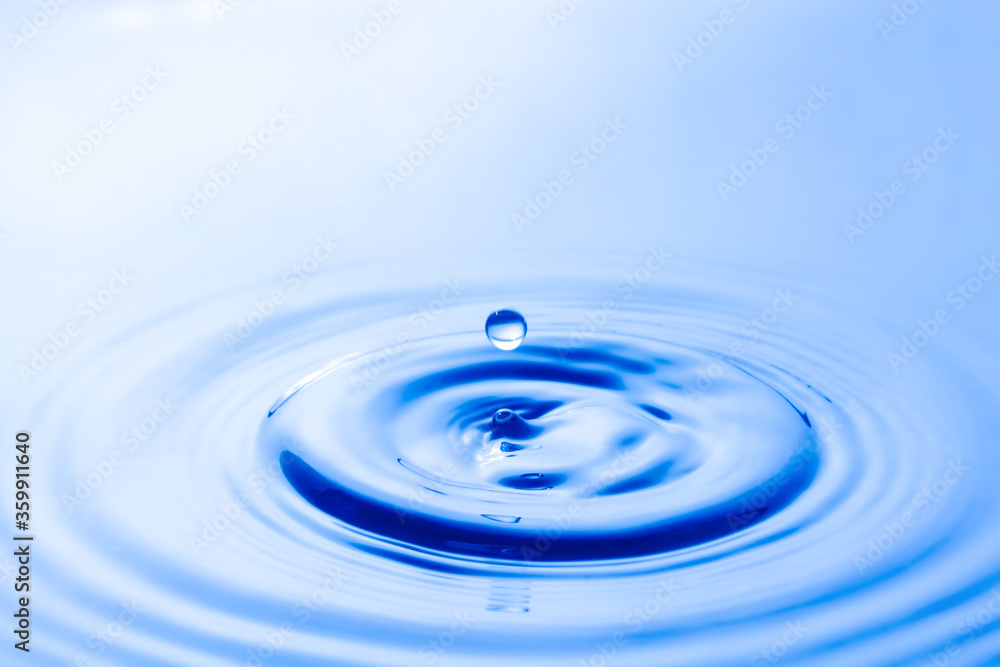 Water droplet falling impact with water surface. causing rings on water surface. Water droplet falling impact with water surface. causing rings on water surface.