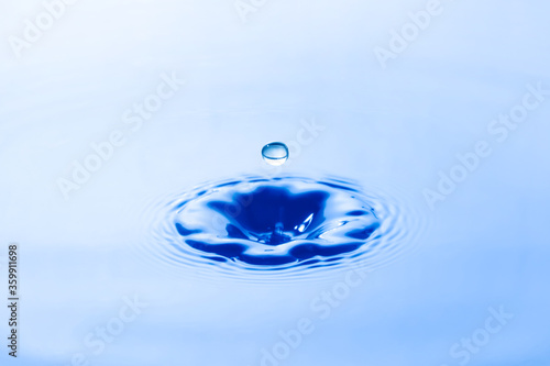 Water droplet falling impact with water surface. causing rings on water surface.