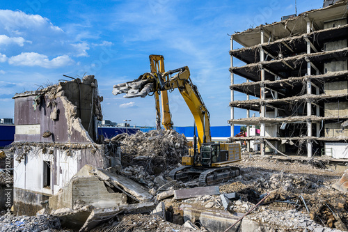 Obraz na plátne Building House Demolition site Excavator with hydraulic crasher machine and yell