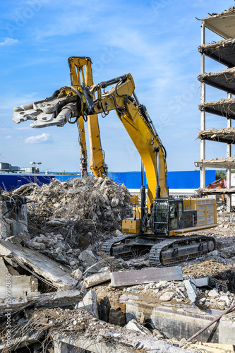 Building House Demolition site Excavator with hydraulic crasher machine and yellow container