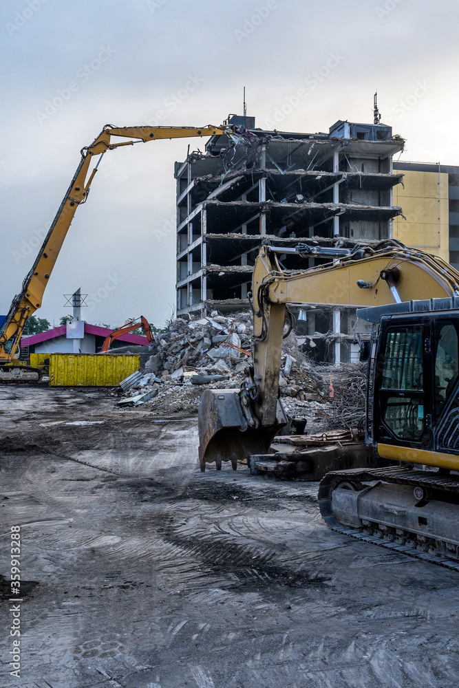 Dawn time Building House Demolition site Excavator with hydraulic crasher machine and yellow container Dawn time Building House Demolition site Excavator with hydraulic crasher machine and yellow container