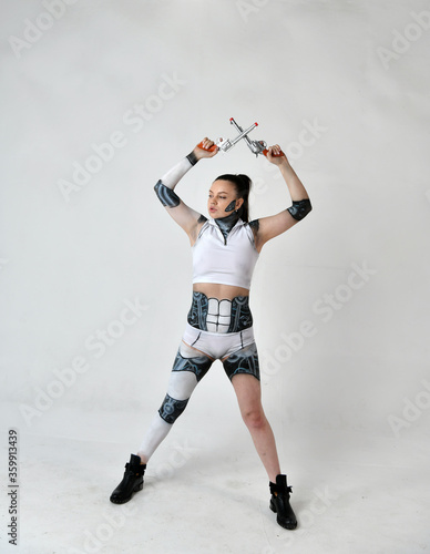 Fototapeta Naklejka Na Ścianę i Meble -  beautiful girl in robot clothes posing with silver revolvers