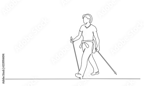 Woman walks on foot with walking sticks. Nordic walking