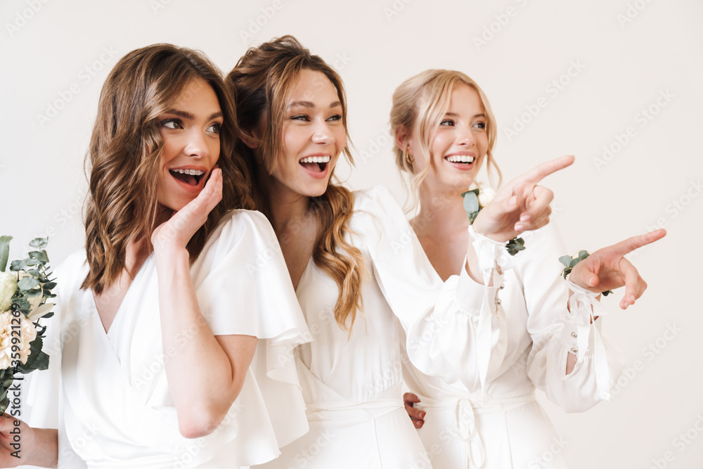 Photo of excited bride with her bridesmaids pointing fingers aside Photo of excited bride with her bridesmaids pointing fingers aside