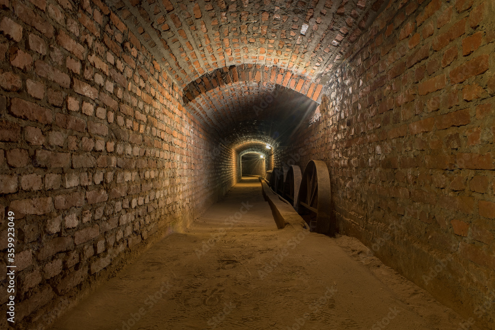 Naklejka premium perspektivische Sicht eines beleuchteten unterirdischen Gang in einem alten Bergwerk