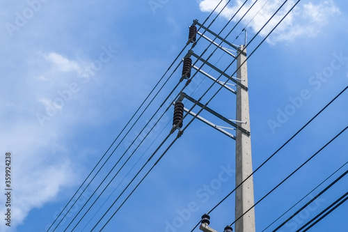 Cement high voltage pole and electric wire with fuse and white cloud with blue sky with copy space. © Jedsada Naeprai