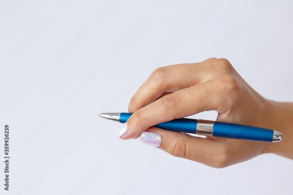 Gesture and sign, female hand holding a metal blue pen on a white background Gesture and sign, female hand holding a metal blue pen on a white background
