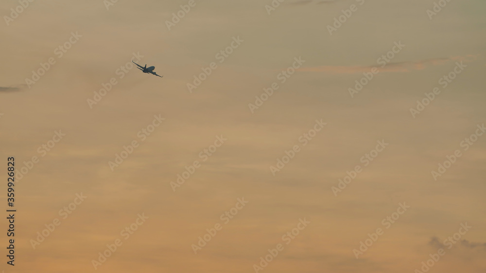 Take-off aircraft against the evening sky after sunset.