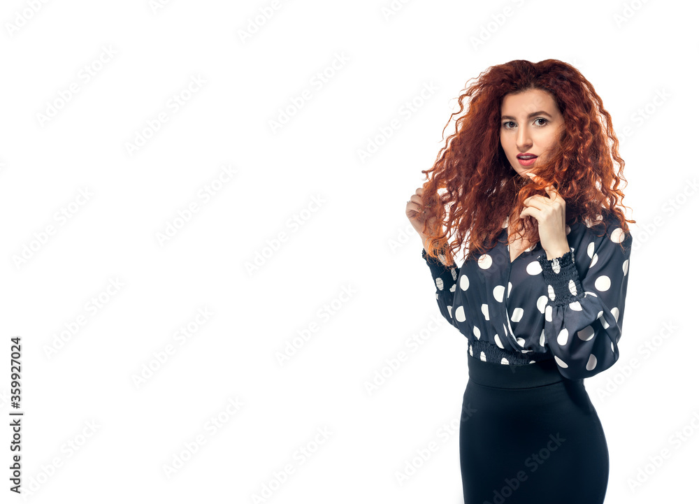 Isolated slender red-haired curly girl in a blouse and a black skirt against a white background. Office employee. Isolated slender red-haired curly girl in a blouse and a black skirt against a white background. Office employee.