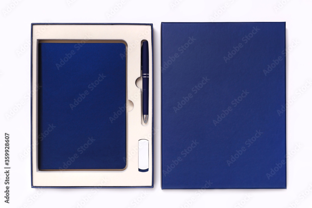 Fototapeta premium Corporate style box with pen, flash drive and notebook isolated on white background. View from above