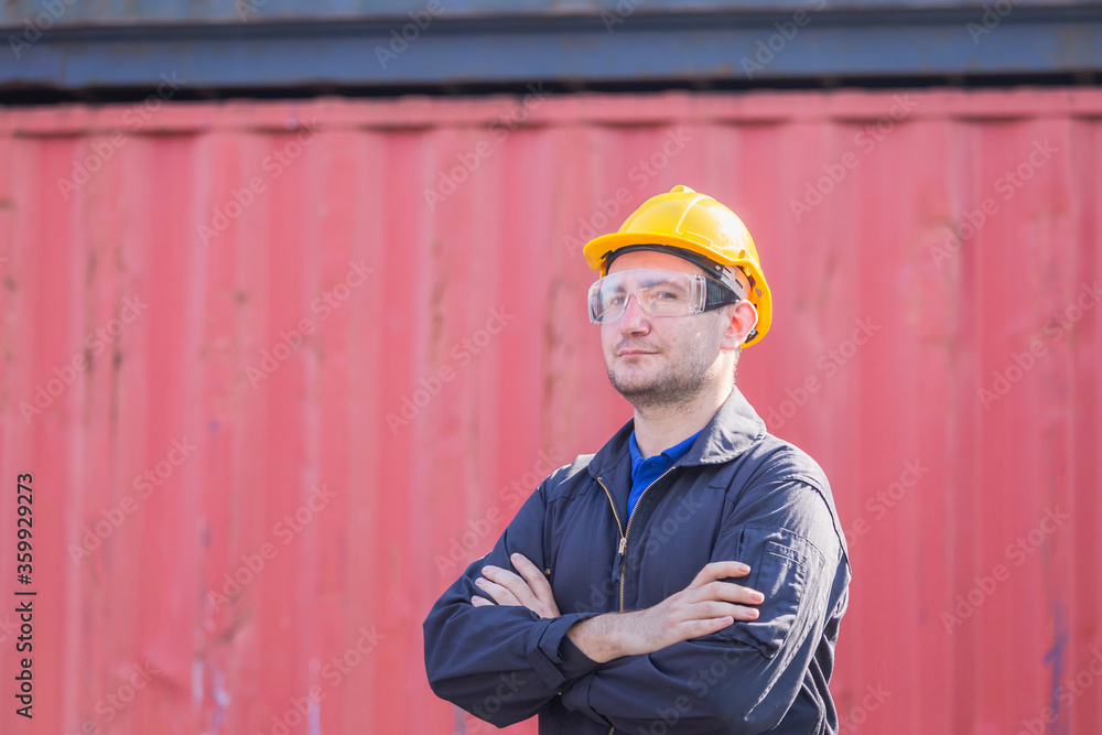 Cheerful factory worker man in hard hat smiling with arms crossed and looking at camera Cheerful factory worker man in hard hat smiling with arms crossed and looking at camera