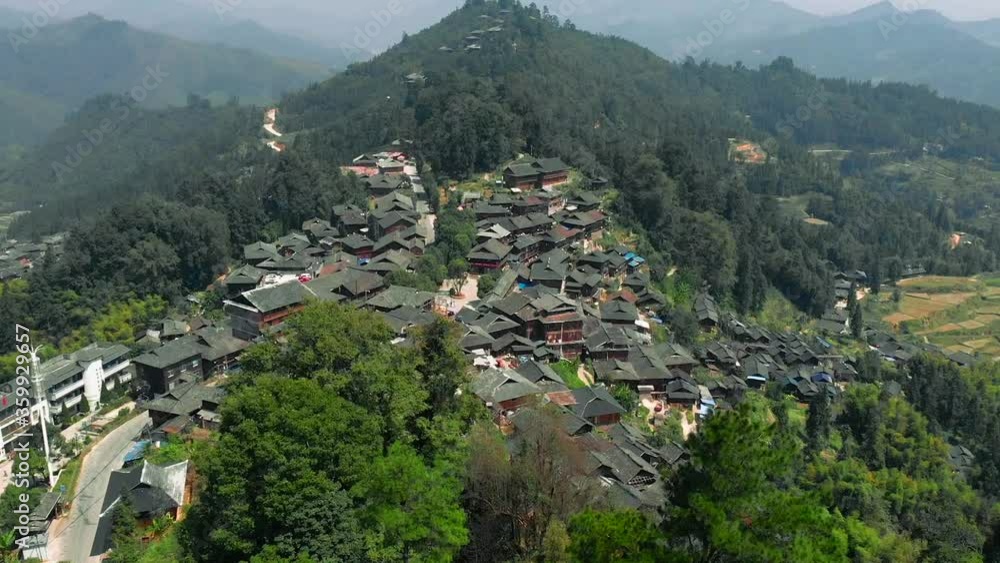 Drone flying high above a small village in the mountains, descending. Tangan Dong Village, China. Drone flying high above a small village in the mountains, descending. Tangan Dong Village, China.