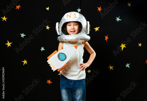 Portrait of a cute little Aisan girl, space at home, dreaming and playing astronaut. Funny family moments