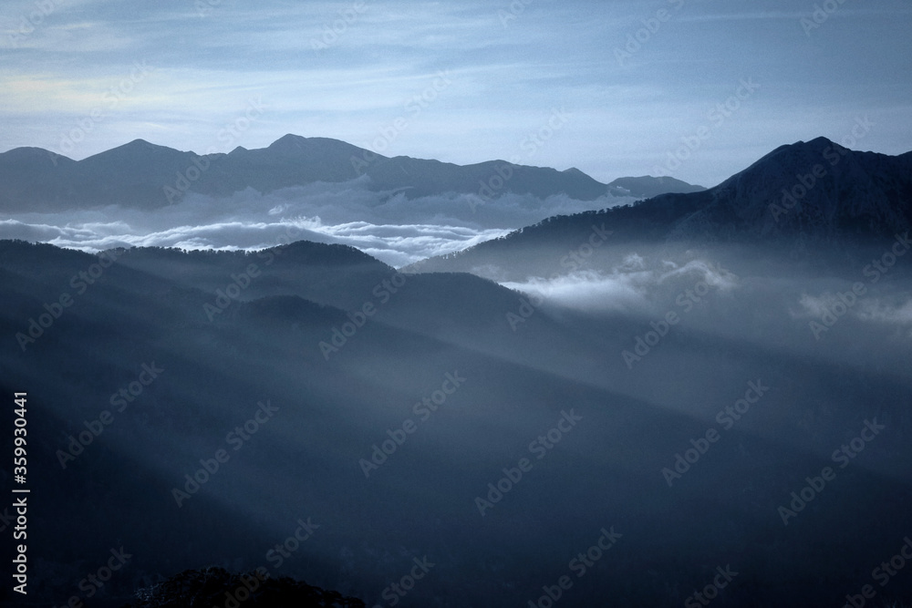 Mountains above the clouds rays of light