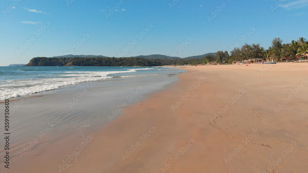 Low drone flight over the waves of Agonda beach. Goa State. India.