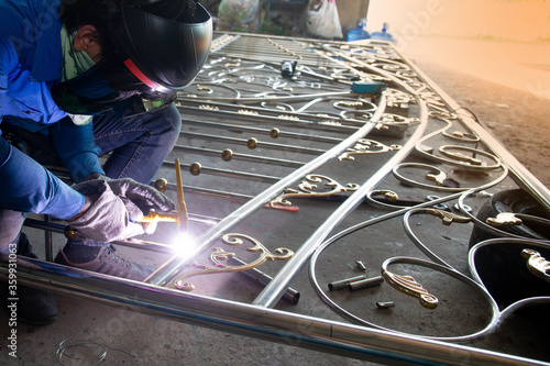 Welders are welding the various parts of building a stainless steel door. photo