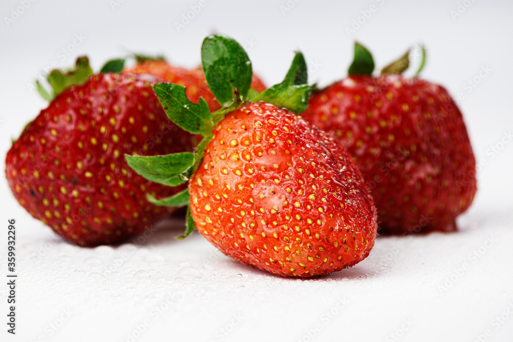 Four strawberries in earthen crumbs on a white background. Four strawberries in earthen crumbs on a white background.