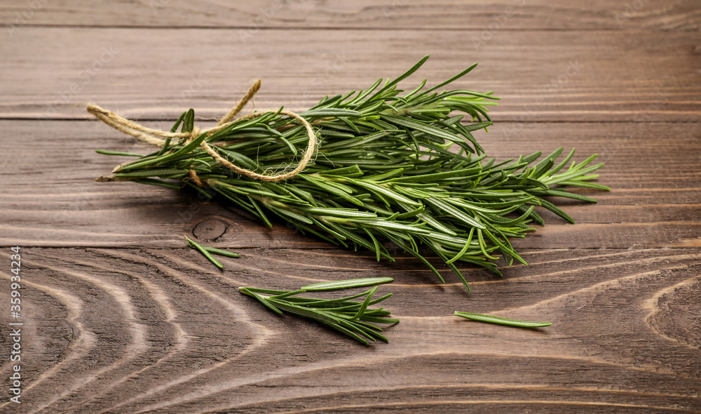 Fresh rosemary sprigs on rustic kitchen table Fresh rosemary sprigs on rustic kitchen table