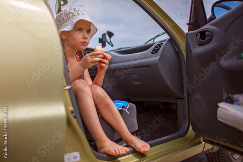 Kids having break during family road trip and eating bread in car on parking, staycation