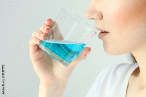 Fotografia young girl uses mouthwash at home