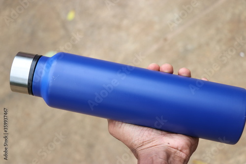Water flask made of stainless steel with space for text and branding held in hand