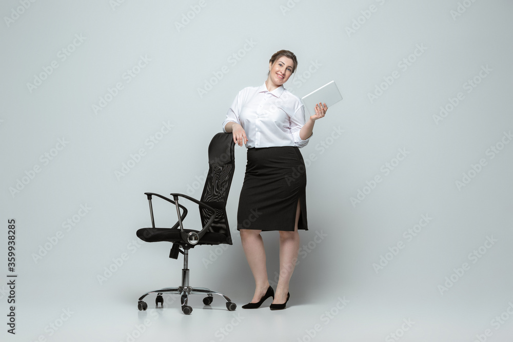 Confident. Young woman in office attire. Bodypositive female character, feminism, loving herself, beauty concept. Plus size businesswoman on gray background. Boss, beautiful. Inclusion, diversity. Confident. Young woman in office attire. Bodypositive female character, feminism, loving herself, beauty concept. Plus size businesswoman on gray background. Boss, beautiful. Inclusion, diversity.