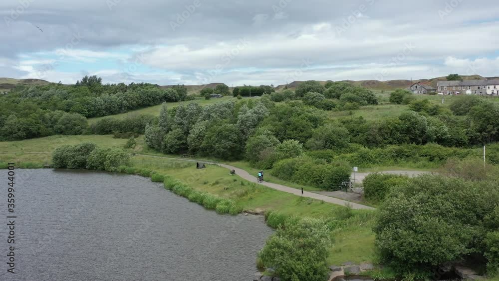 Aerial overhead view of cyclists riding their bikes outdoors in a public park in South Wales UK Aerial overhead view of cyclists riding their bikes outdoors in a public park in South Wales UK