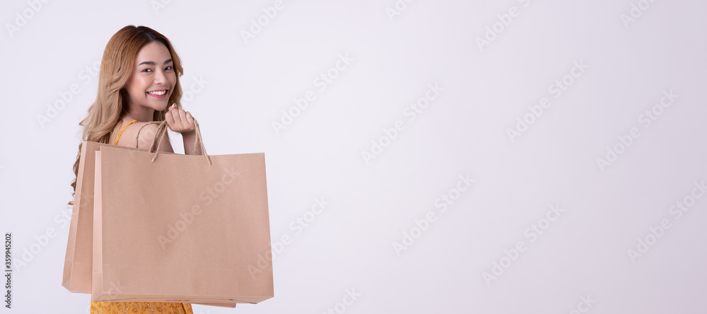 Happy asian woman holding shoppingbag with mid year sale. Happy asian woman holding shoppingbag with mid year sale.