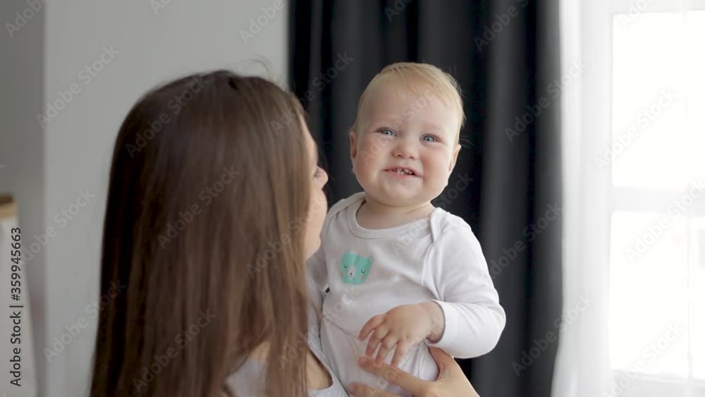 Close-up. The child in his arms. Mom kisses a little baby. The child laughs with happiness. Close-up. The child in his arms. Mom kisses a little baby. The child laughs with happiness.