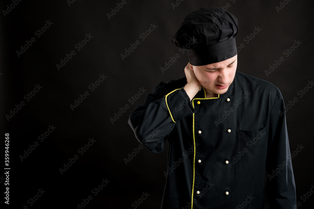 Young male dressed in a black chef suit has sore throat Young male dressed in a black chef suit has sore throat
