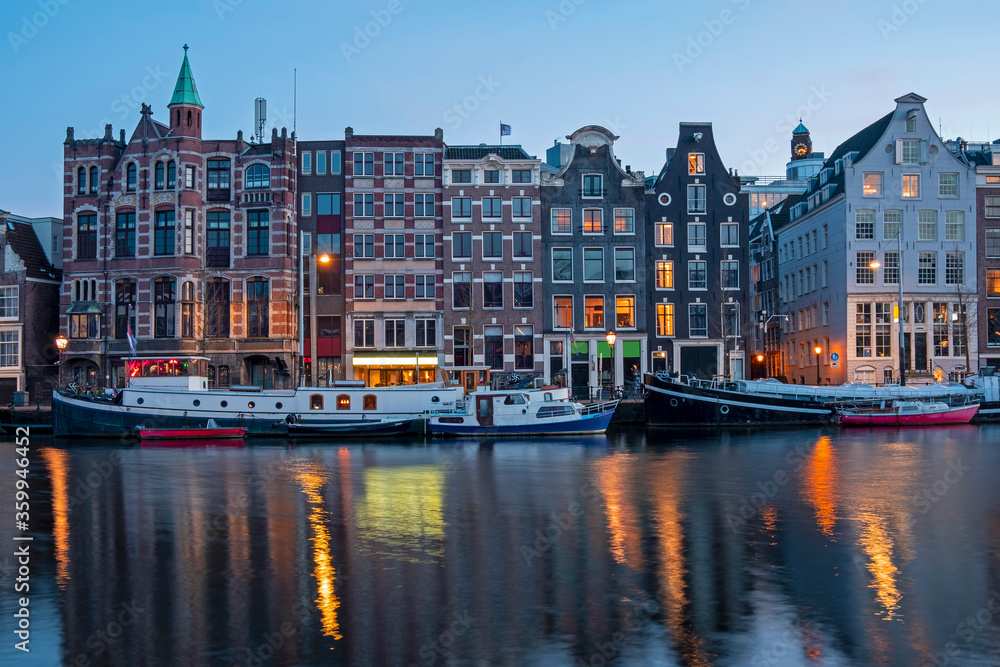 Amsterdam houses and house boats along the Amstel in Amsterdam the Netherlands at sunset