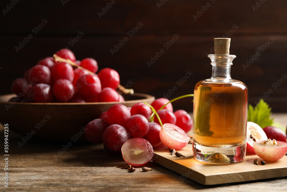Bottle of natural grape seed oil on wooden table, space with text. Organic cosmetic Bottle of natural grape seed oil on wooden table, space with text. Organic cosmetic