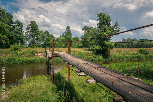 Obraz na płótnie Wooden bridge over the Liwiec river at sunny day Korytnica, Masovia, Poland w salonie