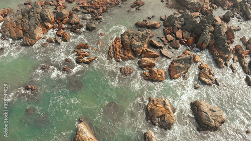 Aerial view rocks and stones on the Arambol beach in North Goa, India.