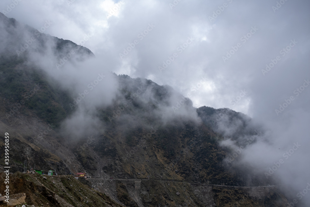 risky hilly rocky road through clouds