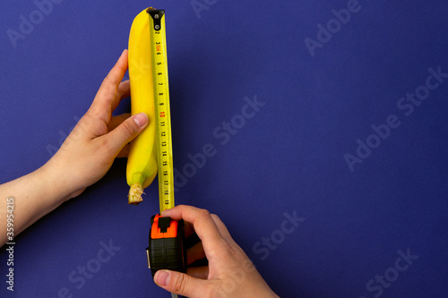 A measuring tape near a banana. The concept of penis enlargement, healthy eating, dieting and weight loss photo