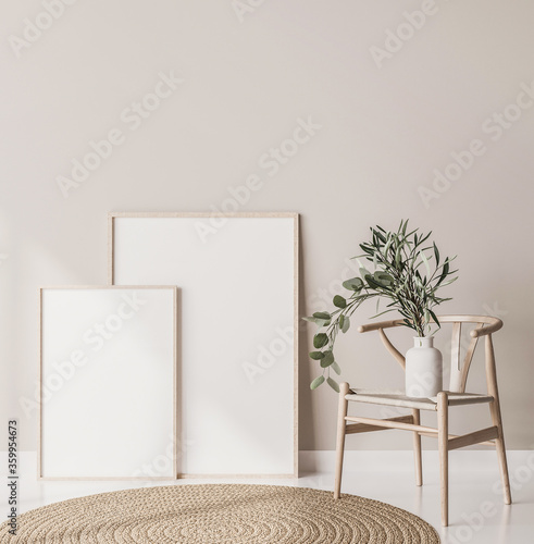Fototapeta Naklejka Na Ścianę i Meble -  Mock up poster frame close up in Scandinavian style home interior. Two wooden frames standing on floor with wooden chair and Eucalyptus plant 3d render
