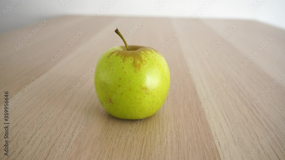 One whole green apple on the table. Camera is slowly moving right One whole green apple on the table. Camera is slowly moving right