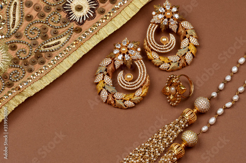 Pearl Jewelry on a brown background, Golden scarf, Pearl bracelet jewelry background, pearl necklace, pearl earrings, finger ring.Style, fashion and design of jewelry. indian traditional jewellery