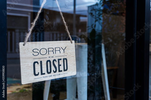 Text on wooden sign "Sorry we're closed " in cafe and restaurant.