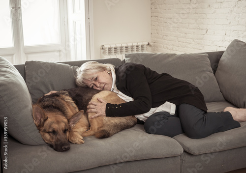 Depressed lonely senior woman in isolation at home with pet dog as only companion
